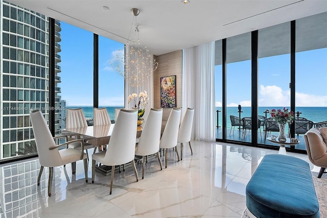 dining space featuring a water view, a wall of windows, and an inviting chandelier