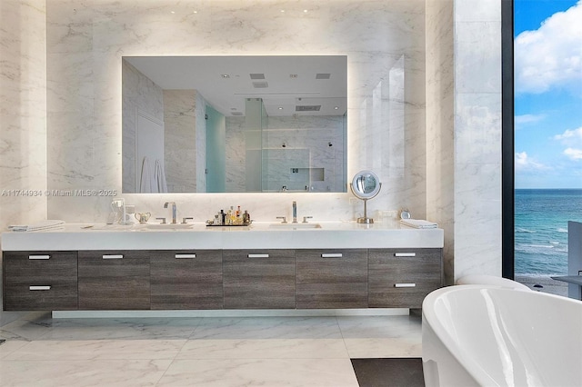 bathroom featuring shower with separate bathtub, a water view, tile walls, and vanity