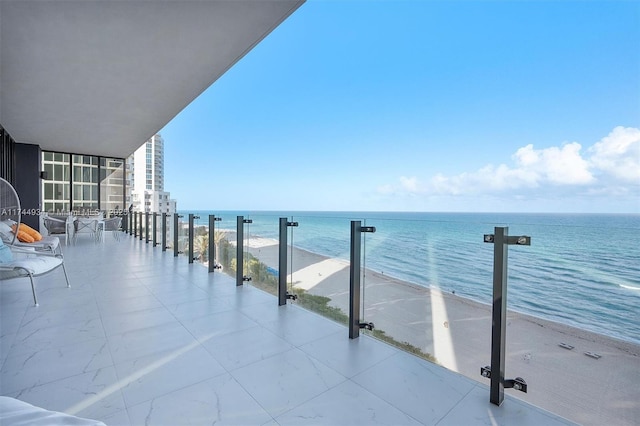 balcony featuring a water view and a view of the beach