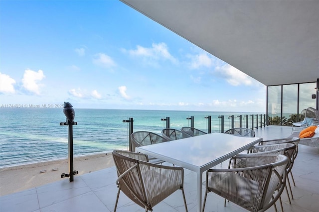 balcony with a water view and a view of the beach