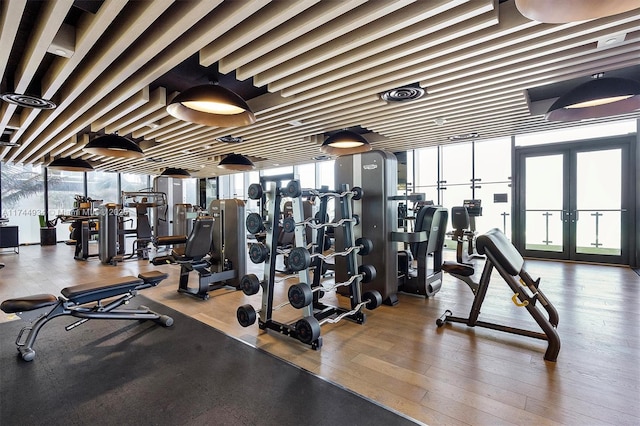 gym featuring hardwood / wood-style floors and french doors