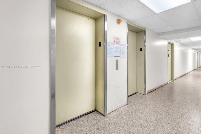 corridor featuring a drop ceiling and elevator