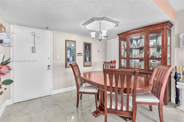 dining area featuring an inviting chandelier and a textured ceiling