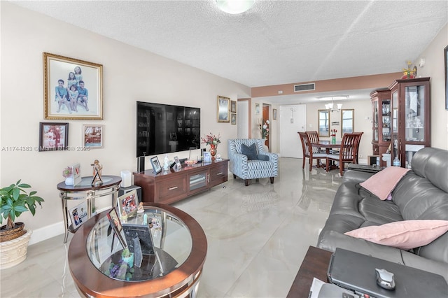 living room with a notable chandelier and a textured ceiling