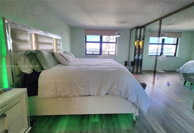 bedroom with multiple windows and wood finished floors