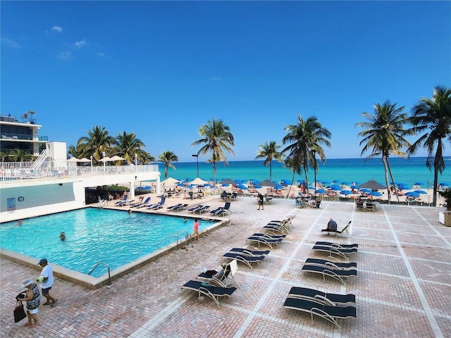community pool with a water view and a patio area