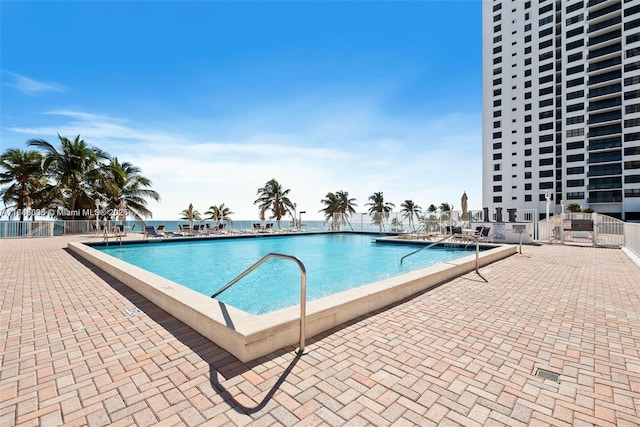 community pool with fence and a patio