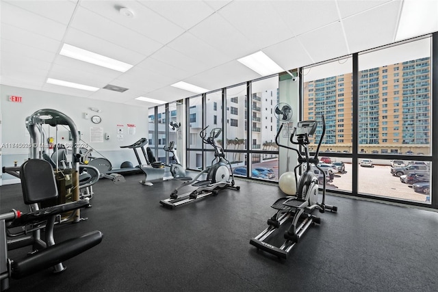 workout area with a drop ceiling and expansive windows