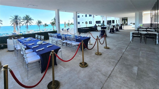exterior space with a patio, outdoor dining area, and a water view