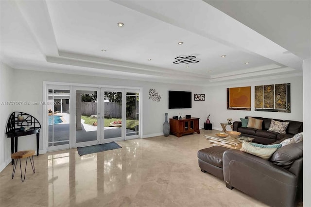 living room with a tray ceiling and french doors