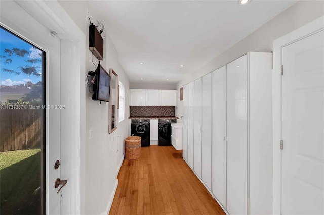 hallway featuring washer and dryer and light hardwood / wood-style flooring