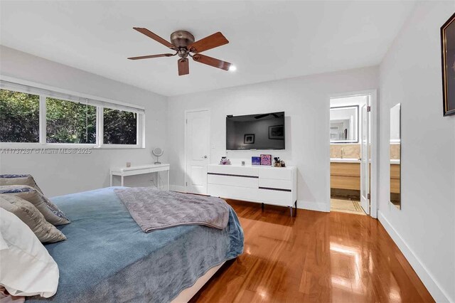 461 NE 115th St, Miami, FL 33161 - bedroom with wood finished floors, baseboards, connected bathroom, and ceiling fan