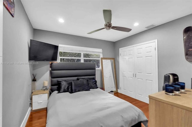 bedroom featuring dark hardwood / wood-style flooring, a closet, and ceiling fan