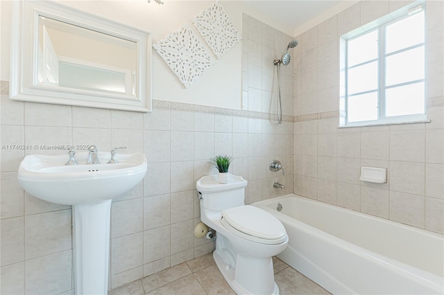 bathroom featuring tiled shower / bath combo, tile patterned flooring, tile walls, and toilet