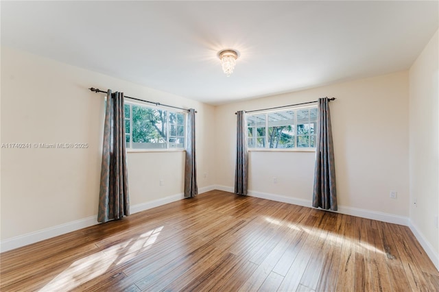 unfurnished room with hardwood / wood-style flooring