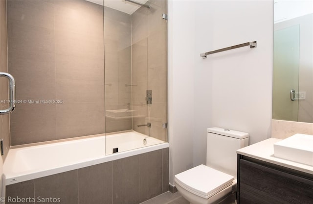 full bathroom featuring vanity, shower / bath combination with glass door, and toilet