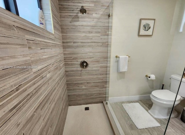 bathroom with a tile shower and toilet