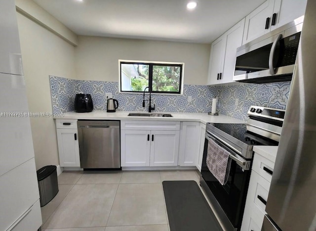 kitchen featuring stainless steel appliances, white cabinetry, sink, and tasteful backsplash