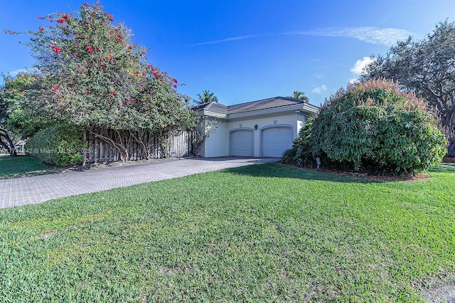 view of front of property with a front yard, decorative driveway, an attached garage, and stucco siding