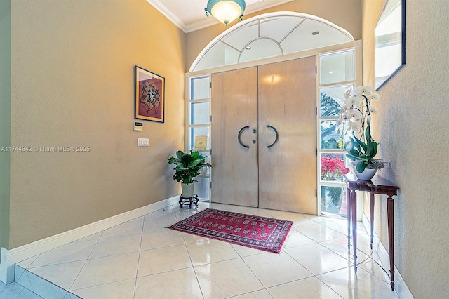 tiled foyer with crown molding, a textured wall, baseboards, and a wealth of natural light