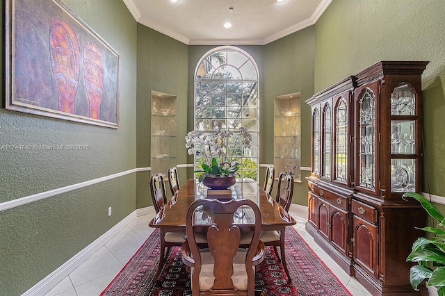 dining area with crown molding, light tile patterned floors, a textured wall, and baseboards