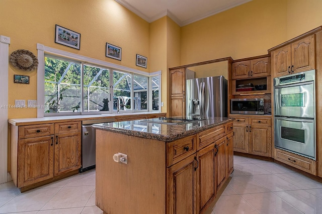 kitchen featuring light tile patterned flooring, a kitchen island, stainless steel appliances, and crown molding