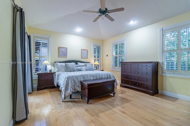 bedroom with multiple windows, lofted ceiling, and light wood-style flooring