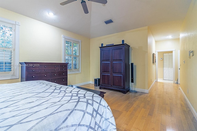 bedroom featuring visible vents, ceiling fan, baseboards, and wood finished floors