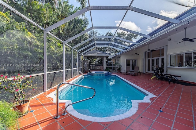 view of pool with a pool with connected hot tub, ceiling fan, glass enclosure, french doors, and a patio area