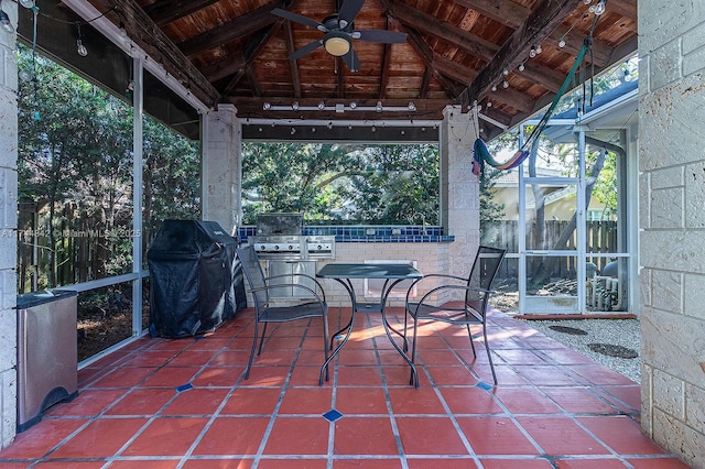 sunroom featuring vaulted ceiling with beams, wood ceiling, and a ceiling fan