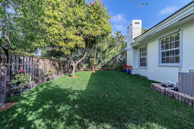 view of yard with a fenced backyard and central AC