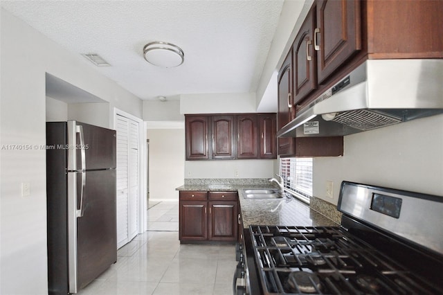 kitchen featuring stainless steel appliances, sink, a textured ceiling, and dark stone counters