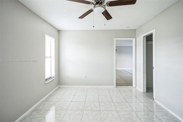 unfurnished room featuring ceiling fan and a textured ceiling