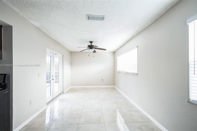 unfurnished room featuring light tile patterned floors, french doors, a textured ceiling, and ceiling fan