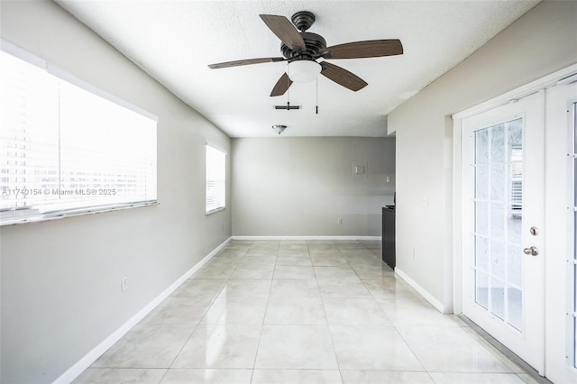 tiled spare room featuring french doors and ceiling fan