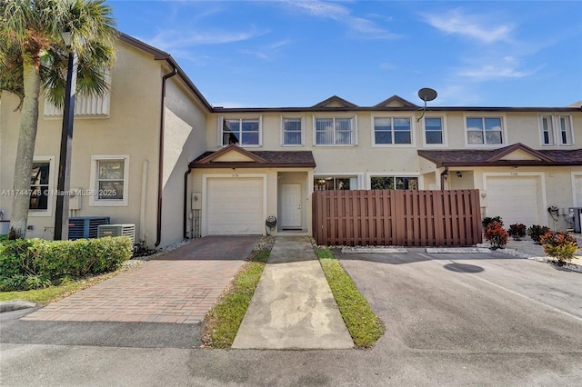 view of front of property with a garage and cooling unit