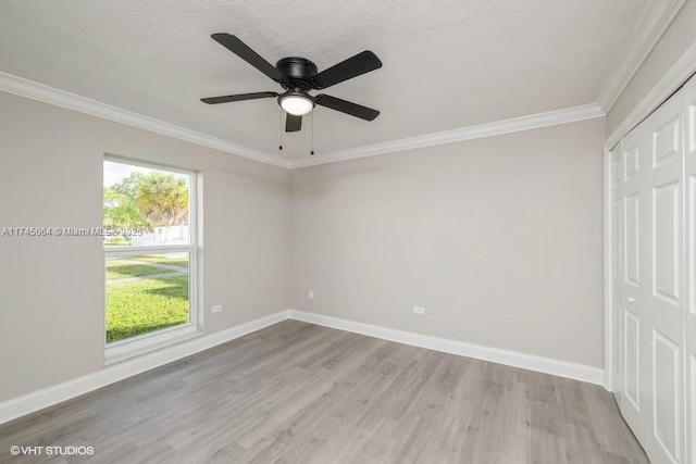 spare room with ornamental molding, ceiling fan, a textured ceiling, and light wood-type flooring