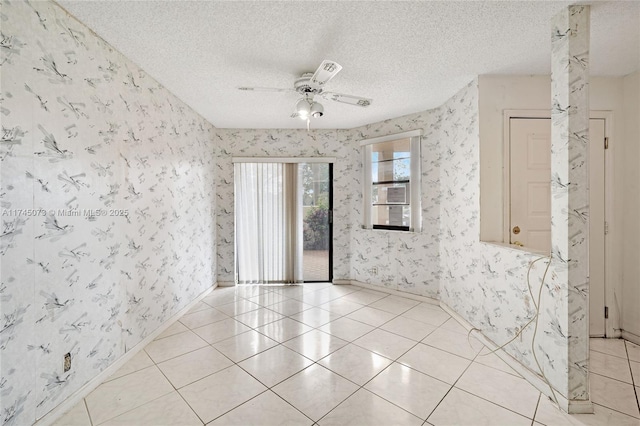 spare room with ceiling fan, light tile patterned floors, a textured ceiling, and wallpapered walls