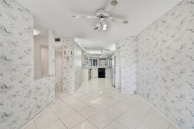 hallway with light tile patterned flooring, visible vents, and wallpapered walls