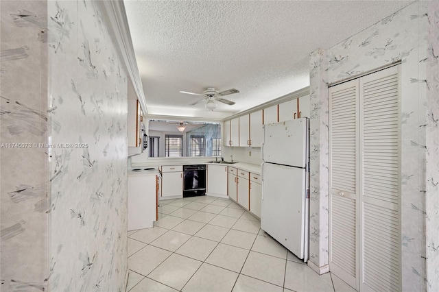 kitchen featuring a sink, light countertops, range, and freestanding refrigerator