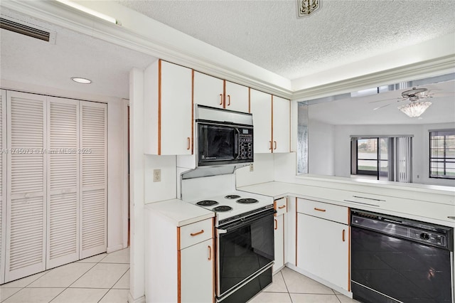 kitchen with light tile patterned floors, light countertops, visible vents, white cabinetry, and black appliances