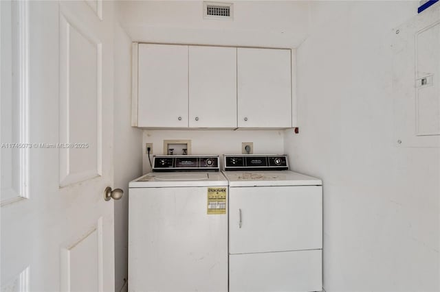 laundry area featuring electric panel, cabinet space, visible vents, and washer and dryer