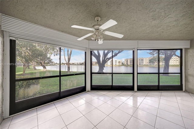 unfurnished sunroom featuring a water view and ceiling fan