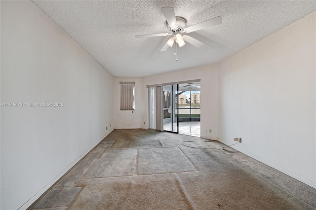 unfurnished room with a textured ceiling, carpet floors, and a ceiling fan