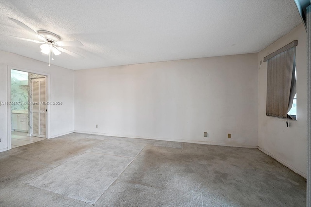 spare room with carpet floors, ceiling fan, and a textured ceiling