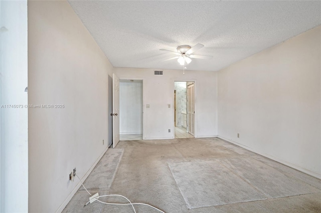 unfurnished room featuring a textured ceiling, ceiling fan, carpet flooring, and visible vents