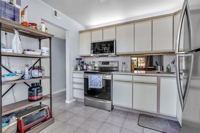 kitchen with appliances with stainless steel finishes and light tile patterned floors