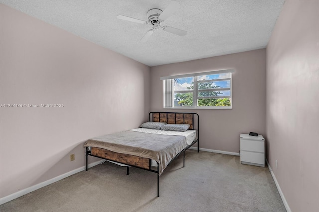 carpeted bedroom with ceiling fan and a textured ceiling