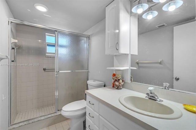 bathroom with vanity, tile patterned floors, a shower with door, and toilet