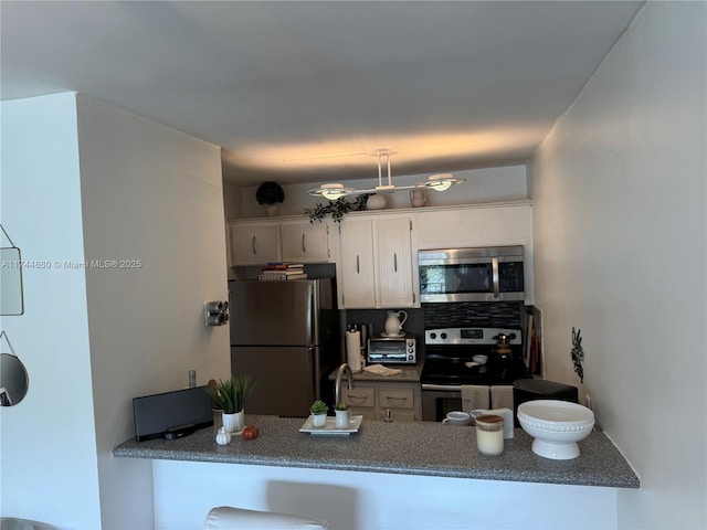 kitchen featuring white cabinetry, decorative backsplash, and stainless steel appliances